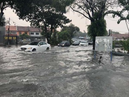 豪雨导致道路淹水，轿车需谨慎涉水而过。