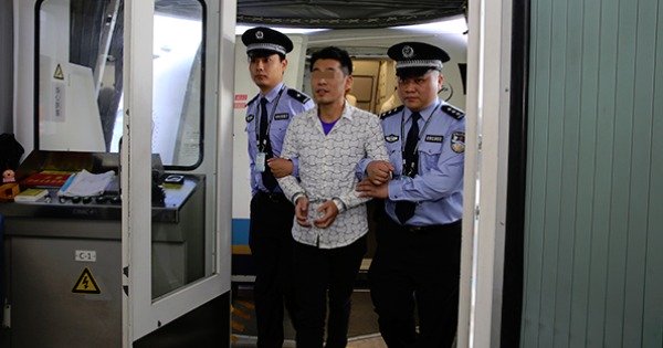 中国民警将嫌疑人宋密秋押下飞机。（网上照片）