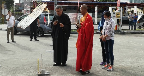 死者越南籍遗孀（白色外套）在两名法师带领下进行招魂仪式。